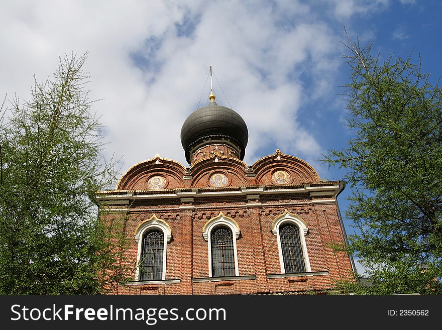 Brick church between green trees, Russia, Moscow. Brick church between green trees, Russia, Moscow