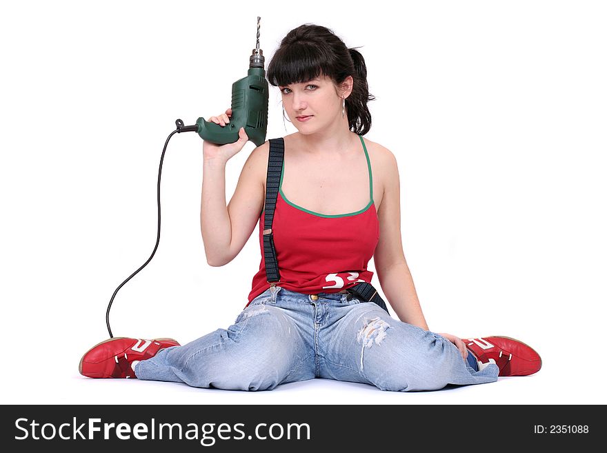 A serious woman sitting with a drill and looking at camera. A serious woman sitting with a drill and looking at camera.
