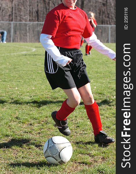 Girl chasing soccer ball down the field. Girl chasing soccer ball down the field.