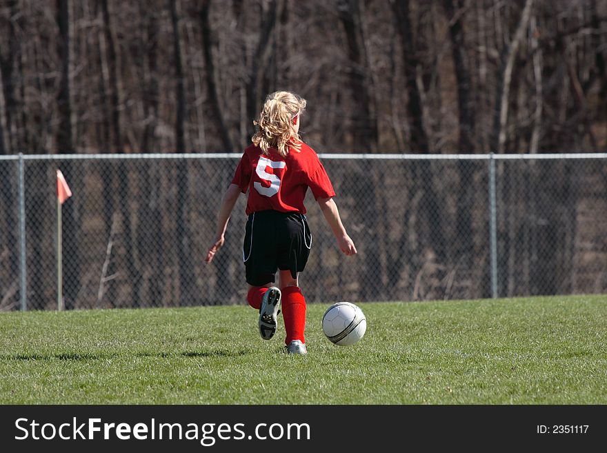 Girls chasing soccer ball down the field. Girls chasing soccer ball down the field.