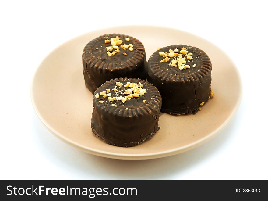 Beautiful chocolate cookies with nuts in a plate on a white background