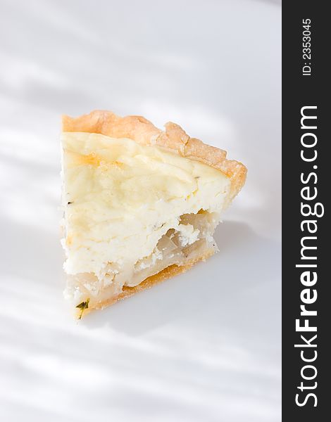 A slice of Goat cheese and onion tart with flour crust. A slice of Goat cheese and onion tart with flour crust