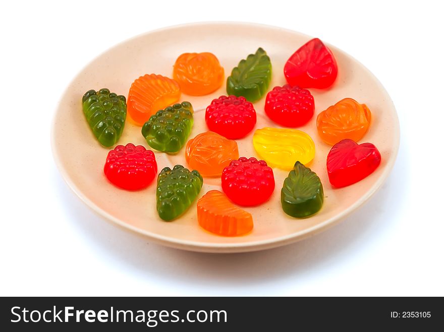 Beautiful fruit candy on a plate on a white background