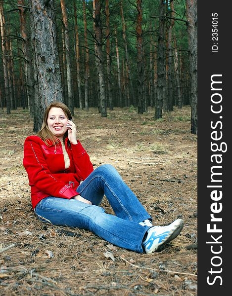 Girl talk for phone sitting under tree