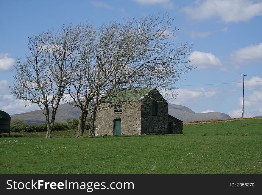 Typical Irish scene of a stone barn, trees, and field. County Mayo, Ireland.