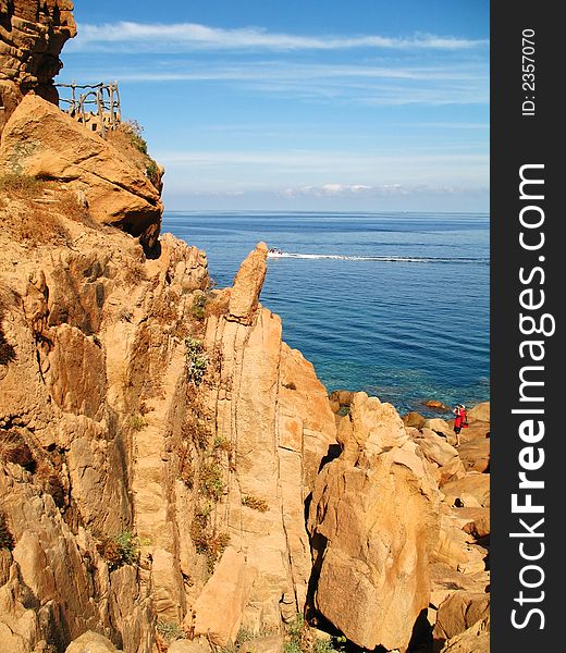 A photographer in the bottom right who is taking a picture of these wonderful rocks in Sardinia (Italy)