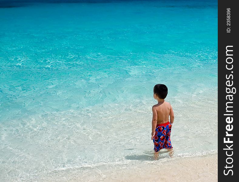 Young boy looking out into the clear blue waters of the Bahamas. Young boy looking out into the clear blue waters of the Bahamas