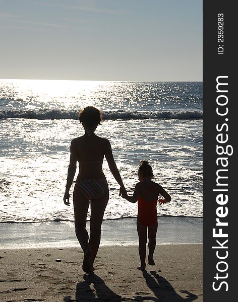Mother and child on the beach at sunset. Mother and child on the beach at sunset