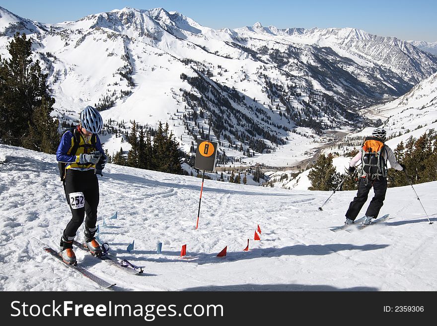 A ski race check point view up close of girl racers changing gear from uphill climbing to downhill skiing