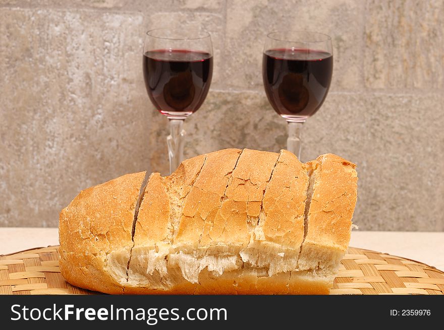 Slices of bread and two glasses of wine in background