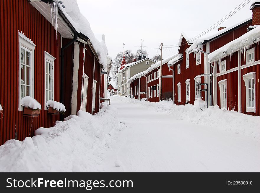 Snowy street in north Sweden with red houses