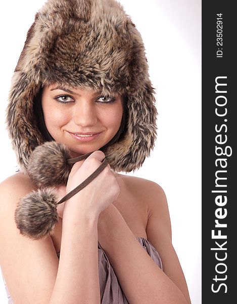 Beautiful young girl with fur hat on a white background