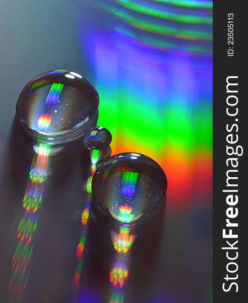 Water drops on a DVD with rainbow of colors reflected off surface