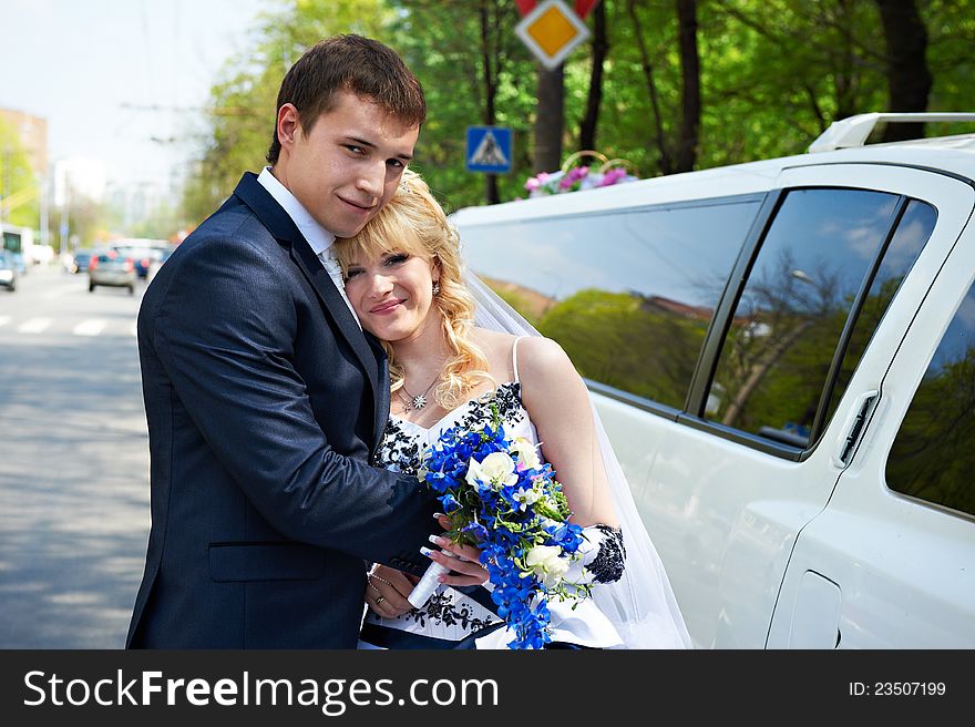 Happy bride and groom about limousine in wedding day