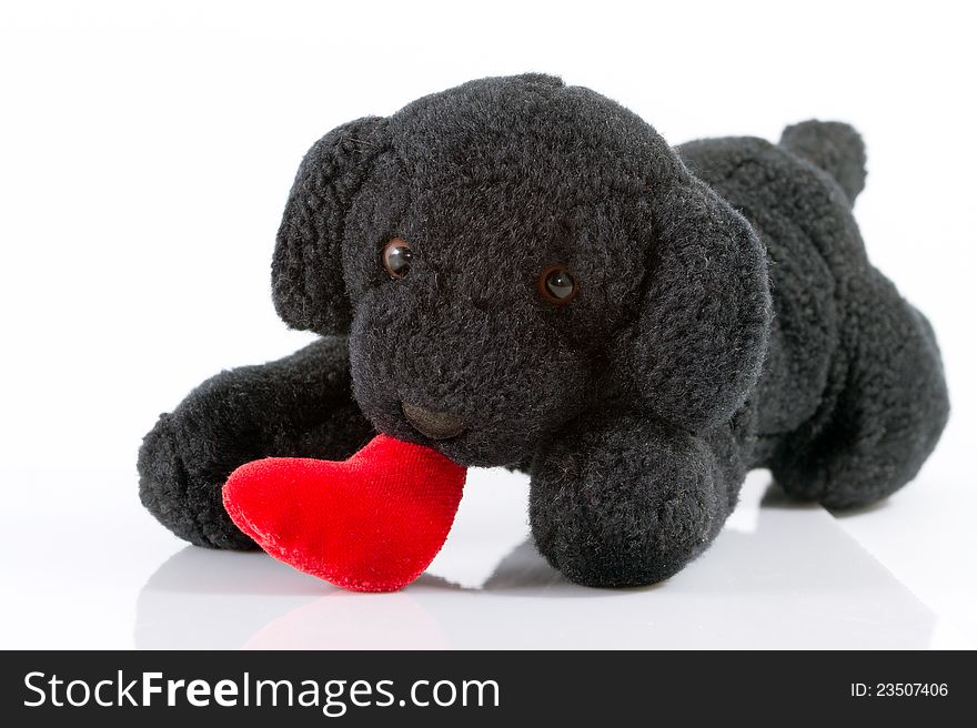 The puppy toy holds heart on mouth. The puppy toy holds heart on mouth