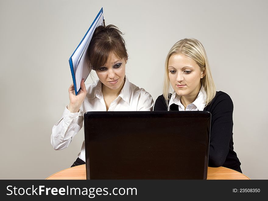 Beautiful girls dissatisfaction with the look of the laptop keep the documents at the table