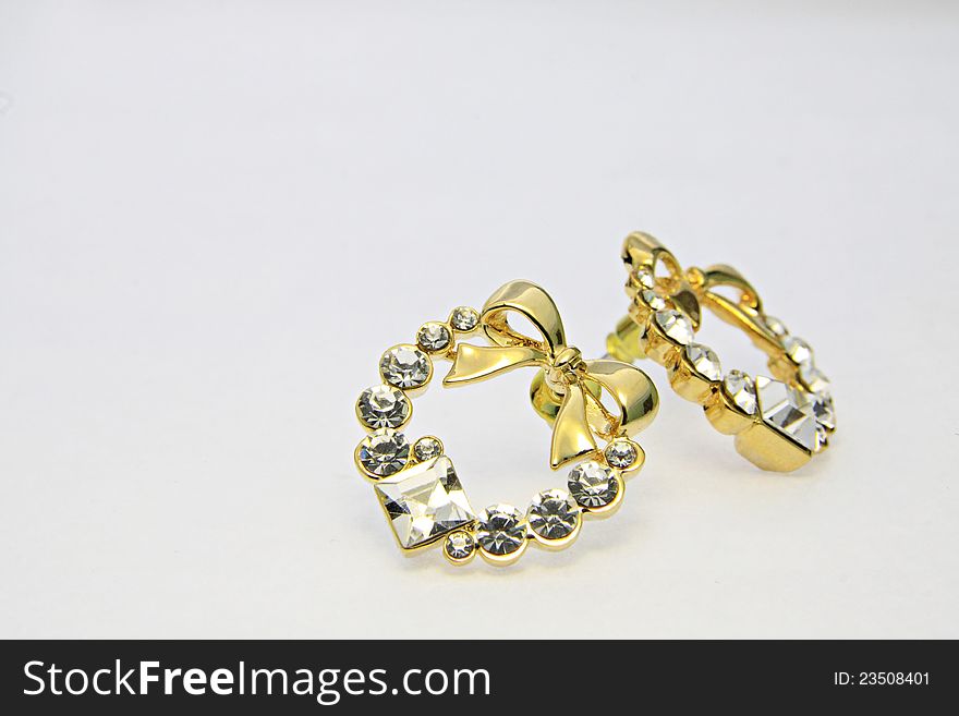 Gold earrings on the white background. Gold earrings on the white background