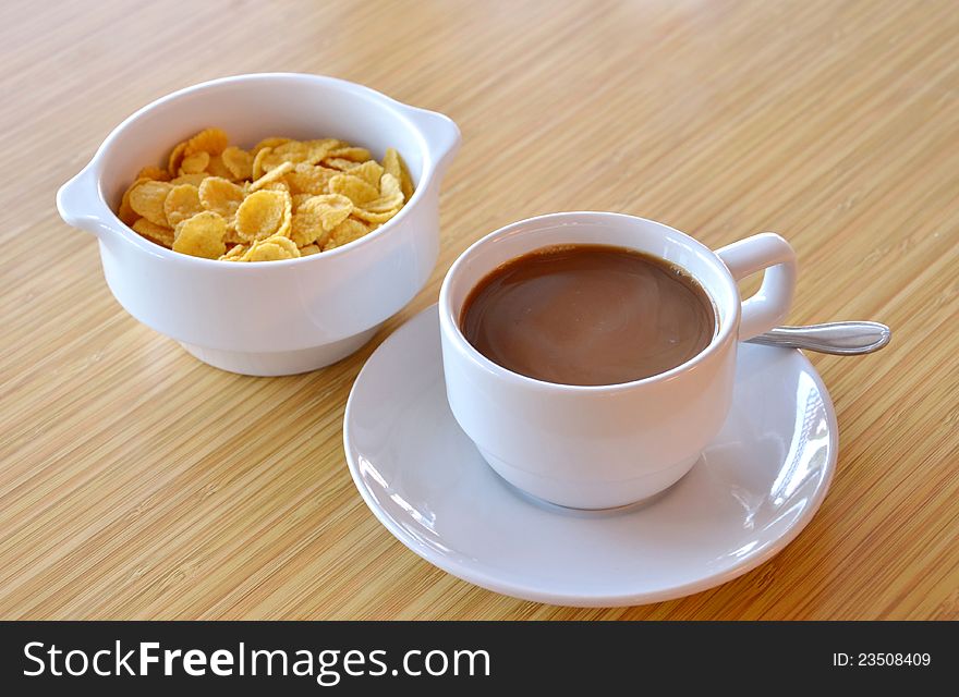 Cup of black coffee and cornflakes on the  table. Cup of black coffee and cornflakes on the  table