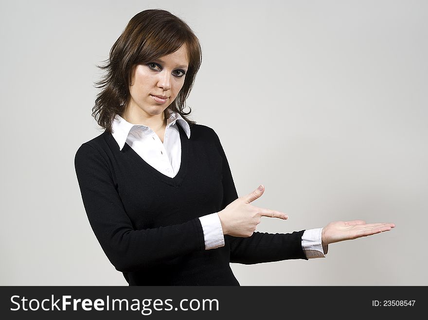Beautiful girl indicates standing finger on the palm of his hand on the background of. Beautiful girl indicates standing finger on the palm of his hand on the background of