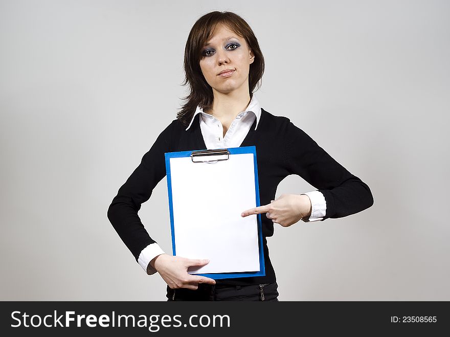 Beautiful girl indicates the document finger on the background of. Beautiful girl indicates the document finger on the background of