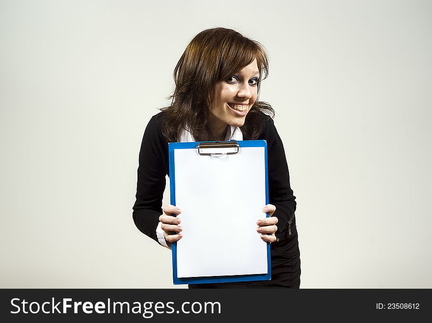 Beautiful girl smiling awkwardly indicates the document on the background of. Beautiful girl smiling awkwardly indicates the document on the background of