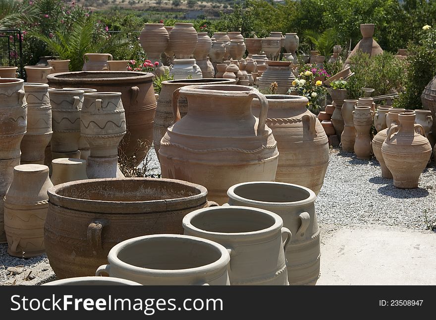 Various clay  pots stacked in an open-air market.