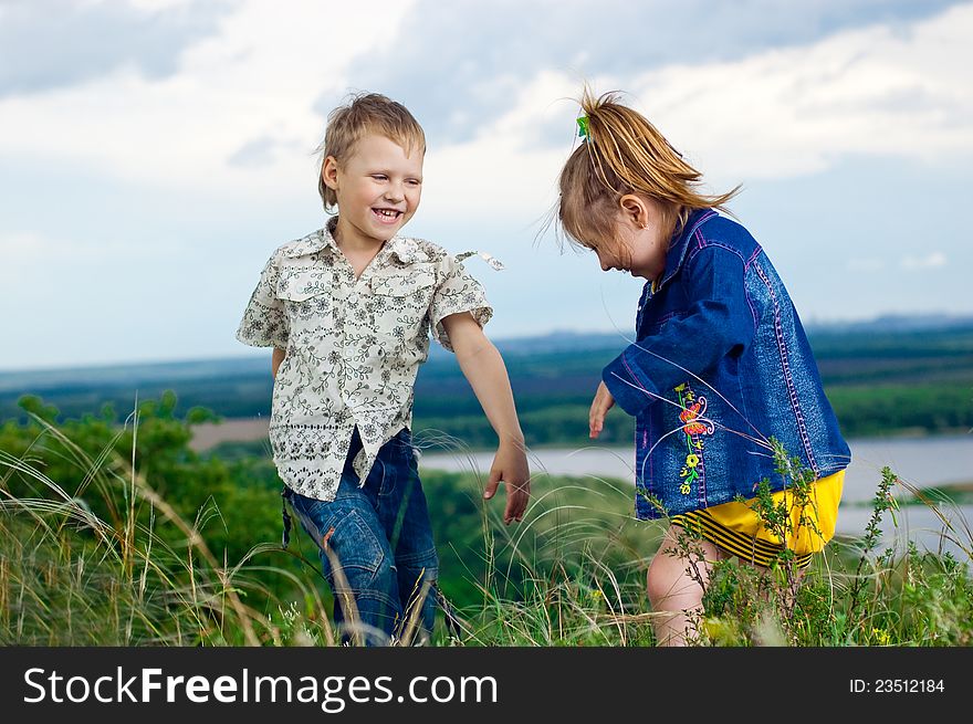 A little girl and boy play and cheered on a walk outdoors. A little girl and boy play and cheered on a walk outdoors