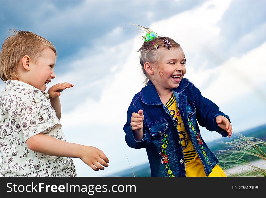 A little girl and boy play and cheered outdoors