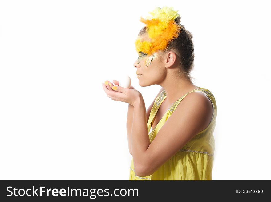 Picture of an easter girl dressed in yellow, with eggs in her hair and hands, on a white, isolated background