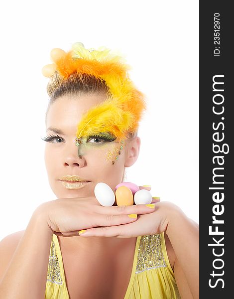 Picture of an easter girl dressed in yellow, with eggs in her hair and hands, on a white, isolated background