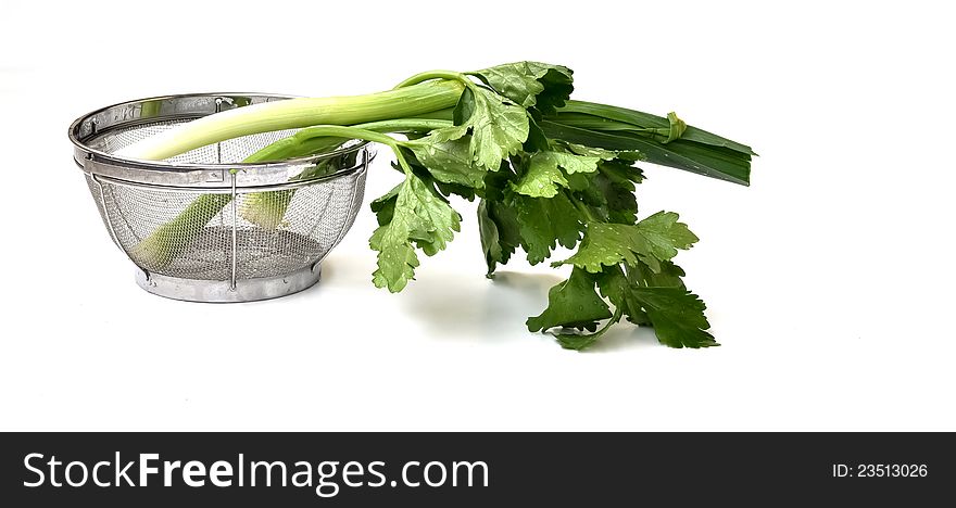 Freshly picked leek leaves that are washed in a strainer. Freshly picked leek leaves that are washed in a strainer