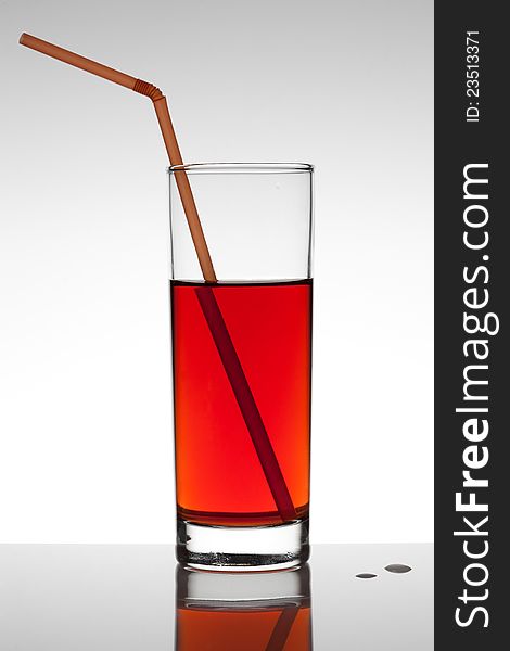 Glass of red fruit juice on white background