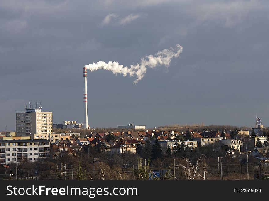 Prague industrial chimney, the smoke from the chimney on a gray background, part of the city with a smoking chimney, the city of Prague with a gray sky on a sunny day, the industry in Prague