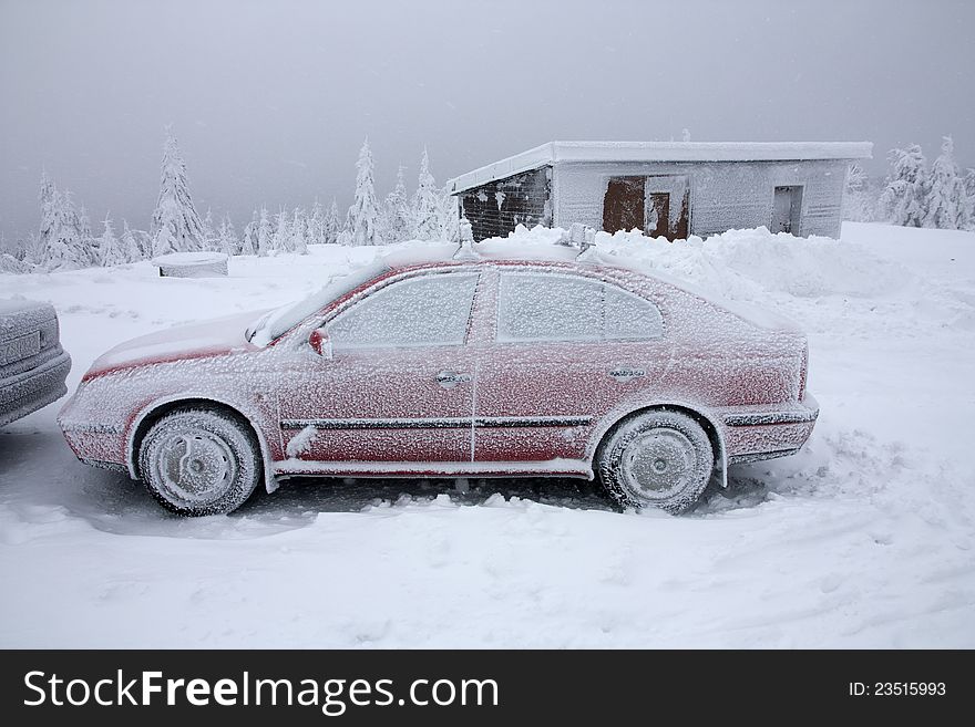 Snow cowered red car