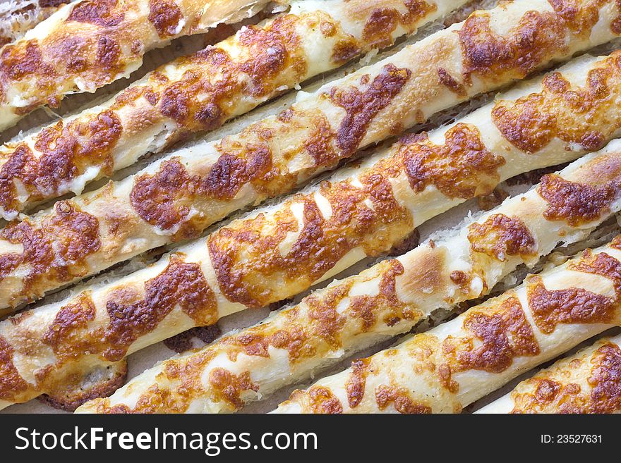 Baked baton texture with cheese crust in close view. Baked baton texture with cheese crust in close view