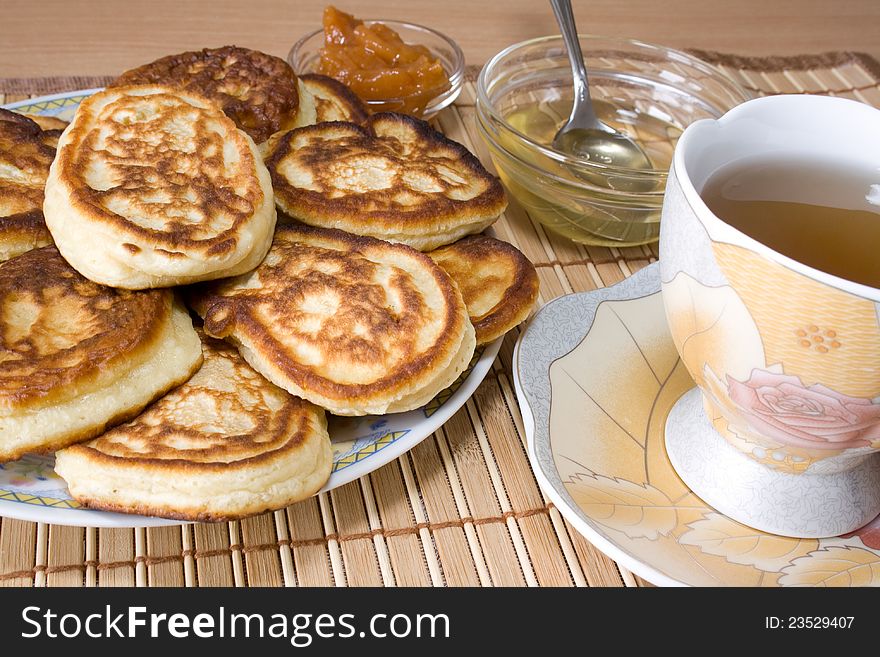 Pancakes, a cup of hot tea, honey and jam for a tasty breakfast. Pancakes, a cup of hot tea, honey and jam for a tasty breakfast