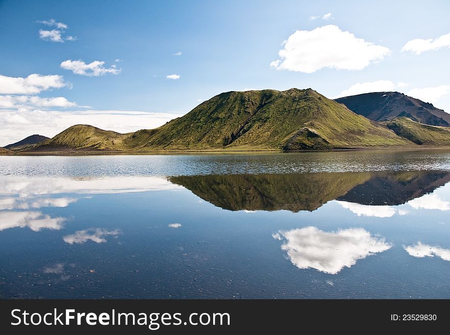 Beautiful mountains reflectng in the lake, clouds