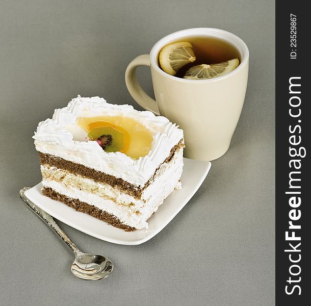 Piece of cake with fruit, tea with , spoon