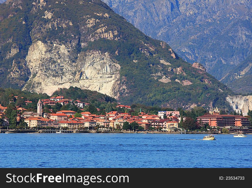 Small town on lake Maggiore and mountains on the background in Northern Italy. Small town on lake Maggiore and mountains on the background in Northern Italy.