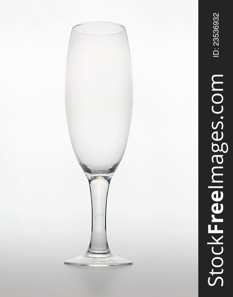 Studio shot of an empty glass for champagne on white matte background with shadow. Studio shot of an empty glass for champagne on white matte background with shadow