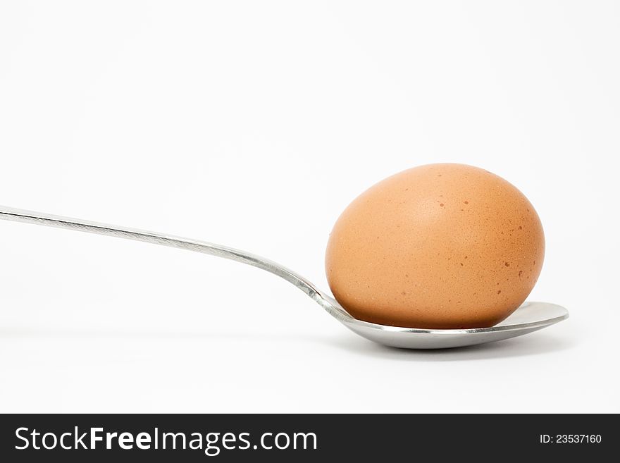 Close up of a fresh egg with a spoon. Close up of a fresh egg with a spoon