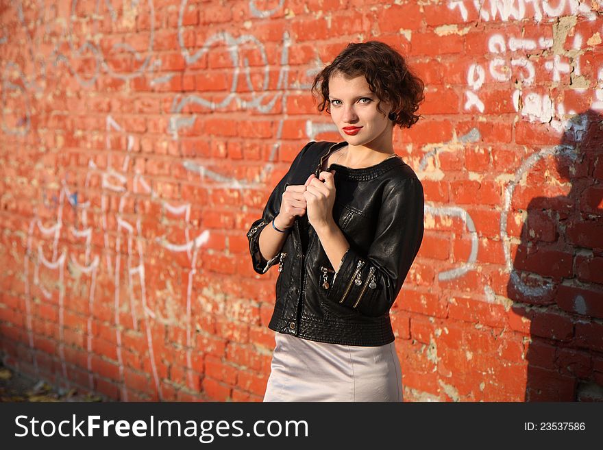 A young girl near the red wall. A young girl near the red wall