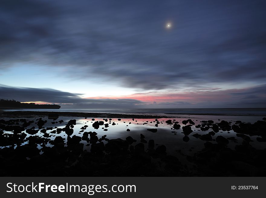 Early morning before sunrise, Beach with lava rocks in the foreground. Early morning before sunrise, Beach with lava rocks in the foreground