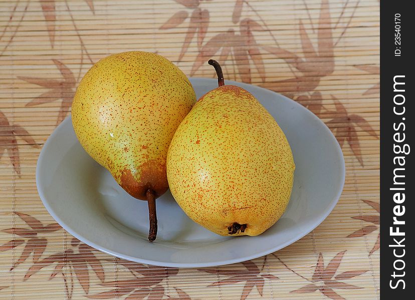 Photographs of two pears on a plate located. Photographs of two pears on a plate located