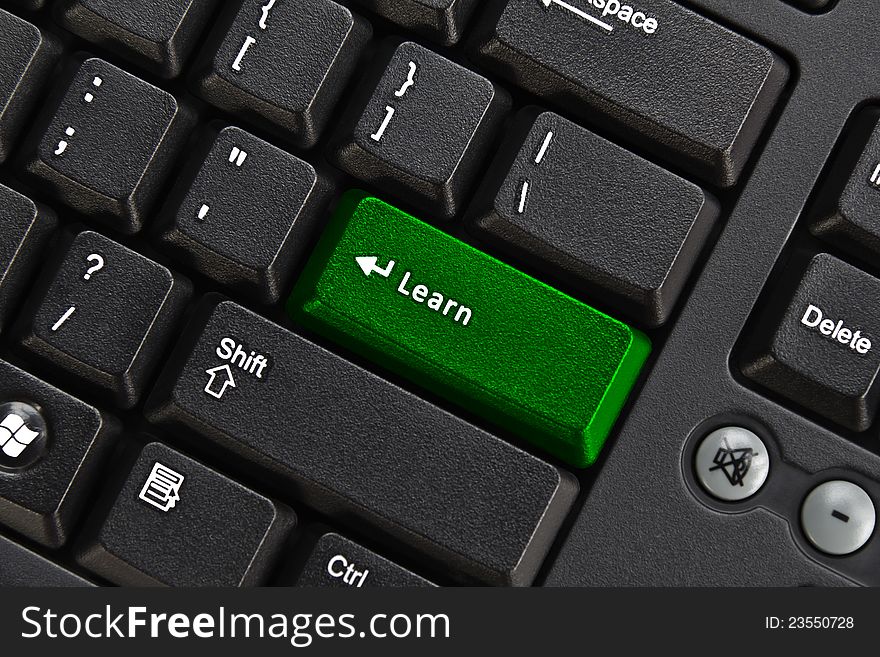 Close up of black pc keyboard, focus on green learn key, education concept