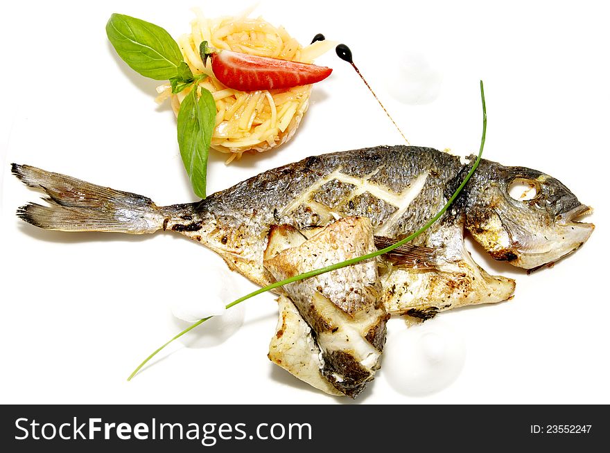 Baked fish with vegetables on a white plate