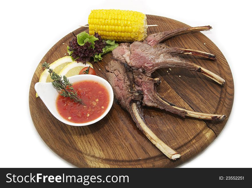 Rib roast on the plate with the sauce and corn. Rib roast on the plate with the sauce and corn