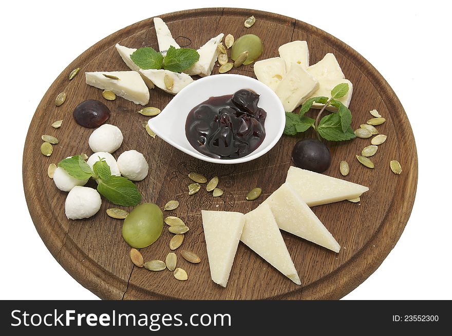 Wooden plate with several varieties of cheese on a white background. Wooden plate with several varieties of cheese on a white background