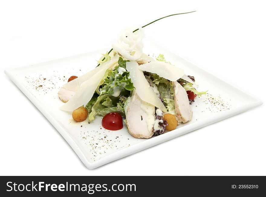 Caesar salad on the plate with the sauce on a white background. Caesar salad on the plate with the sauce on a white background