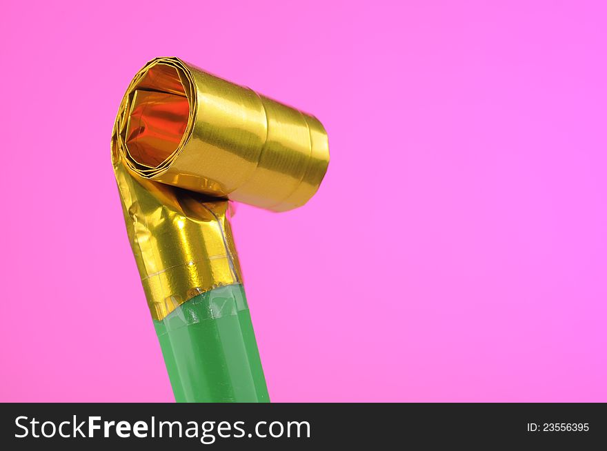 A party blowout (noise maker) on a pink background with copy space. A party blowout (noise maker) on a pink background with copy space